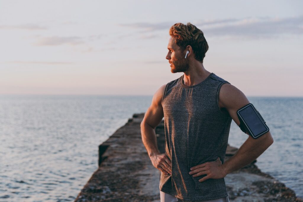 Silhouette of a man standing midstream in a peaceful river.